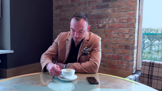 帅哥一个人在咖啡馆喝大杯咖啡视频下载
