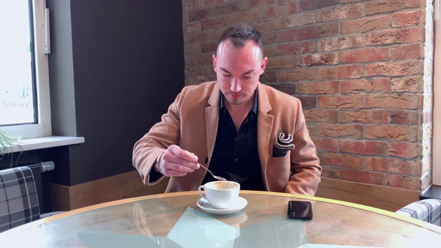 帅哥一个人在咖啡馆喝大杯咖啡视频下载