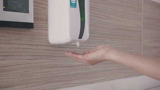 妇女使用自动洗手液来预防感染视频下载