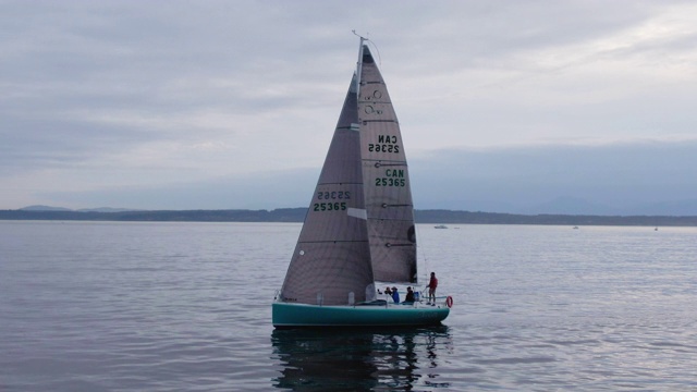 无人机/多莉拍摄的一艘帆船与一个小船员前往普吉特海湾在华盛顿阴天视频素材