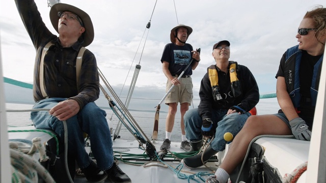 华盛顿州西雅图附近的普吉特海湾，一群人坐在一艘帆船的甲板上交谈视频素材