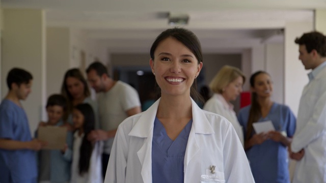 女医生走在医院的走廊上，面带微笑地面对着镜头视频素材