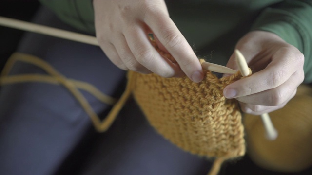 上面角度的女人编织着芥末色的羊毛视频素材
