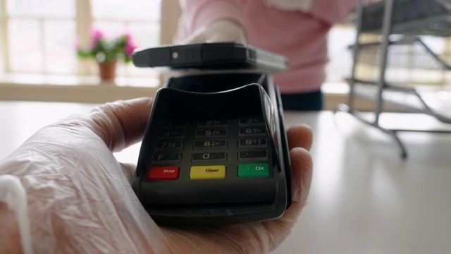 用手机付款。2019冠状病毒病大流行期间，小商店采用NFC技术的非接触式支付。在工作和在城市时戴上防护手套。视频下载