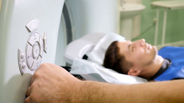 男性病人进入ct扫描仪的特写镜头。医疗设备:计算机断层扫描机在现代诊所。健康的概念。医生按下CT MRI扫描仪设置按钮。高清视频素材