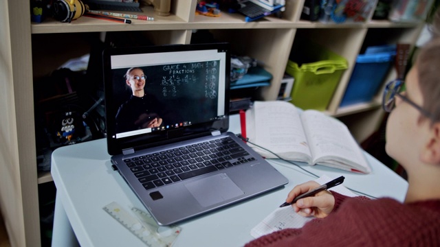 小男孩在他的房间里参加在线学校的课程。视频素材