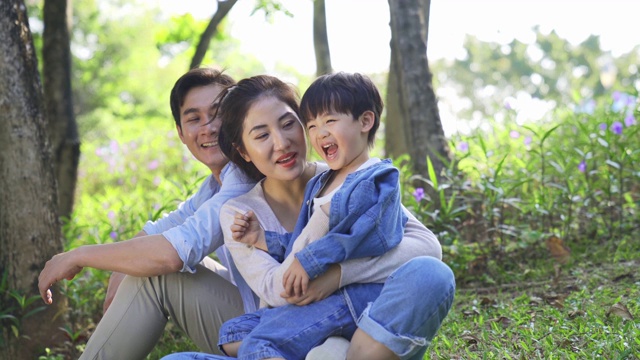 年轻的亚洲父母和孩子在树林里享受大自然视频下载