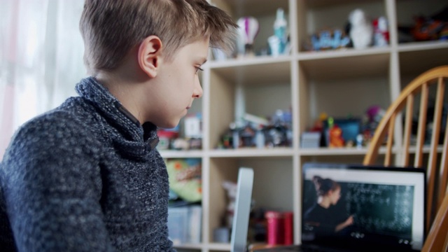 小男孩在他的房间里参加在线学校的课程。视频素材