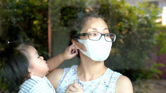母亲戴口罩，儿子因疫情在家视频素材