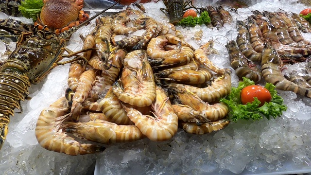 许多新鲜的鱼，虾和其他海鲜在冰在柜台上的市场视频素材