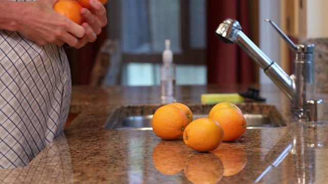 COVID-19男子使用洗手液后将橙子放入冰箱视频素材