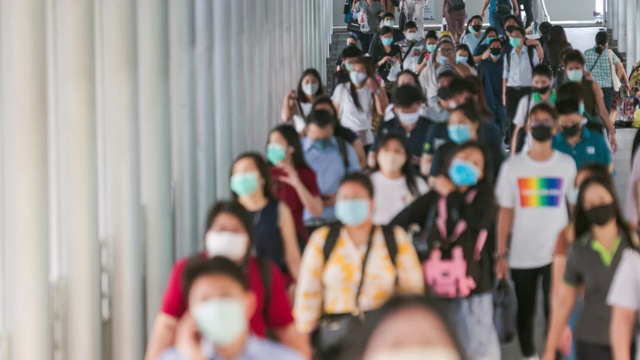 背景:早高峰时间，在曼谷上班时，一群亚洲人戴着预防冠状病毒或新冠病毒的面罩和空气中的微尘pm 2.5视频素材
