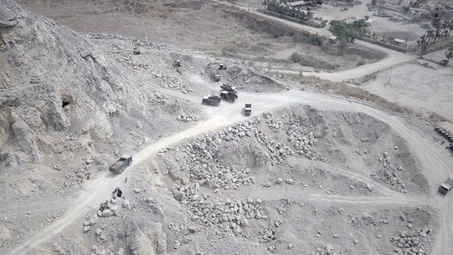 一辆自卸车通过采石场运送岩石的鸟瞰图视频下载