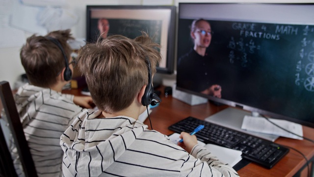 小男孩在COVID-19隔离期间参加在线学校课程。视频素材