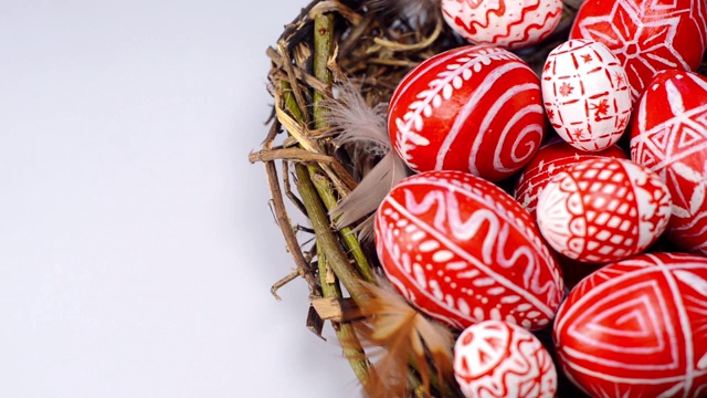 复活节红蛋与民间图案成鸟巢在白色的背景。手加蛋窝。乌克兰传统鸡蛋pisanka和krashanka。视频素材