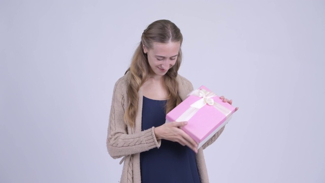 快乐的年轻金发孕妇拿着礼盒视频下载