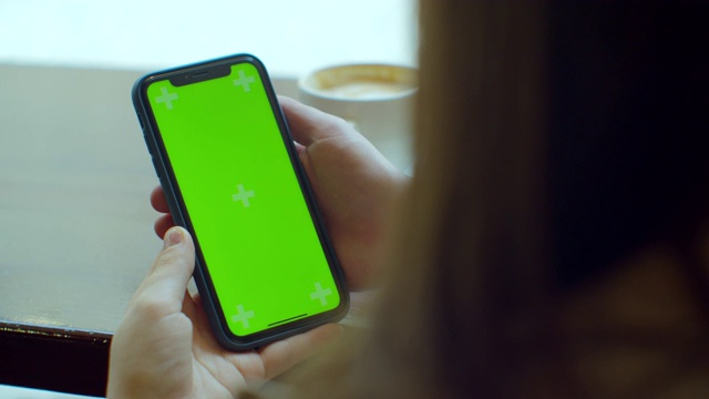 女商人在咖啡馆使用绿色触摸屏的手机。绿色的屏幕。在社交媒体上分享信息。视频素材