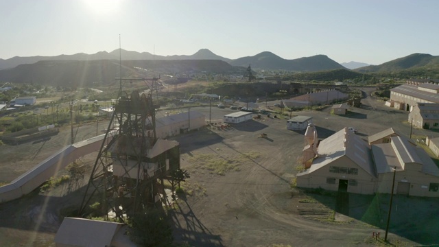 空中拍摄的工厂对天空在阳光明媚的一天，无人机上升的城市附近的山脉-比斯比，亚利桑那州视频下载