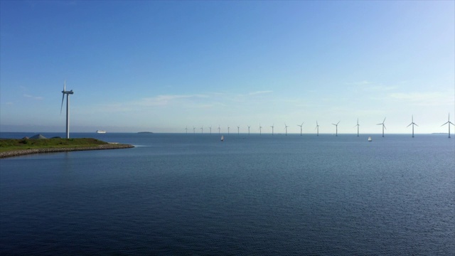 航拍的风力涡轮机在水对天空晴朗的一天，无人机飞向海上的船只-哥本哈根，丹麦视频素材