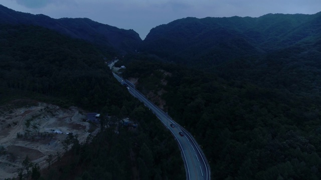 一辆汽车在夜间沿着山路行驶/韩国江原道华川枪视频素材