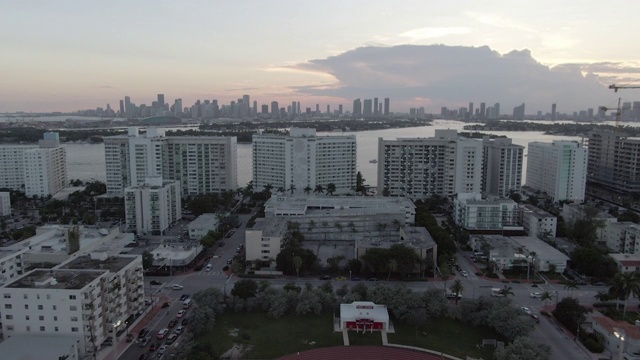 空中拍摄的人在城市体育场对抗天空，无人机飞向建筑物在日落，体育场鸟瞰图视频下载