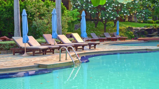椅子池或床池和伞周围的游泳池与海洋背景-假日和度假概念视频下载