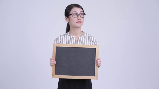 美丽的亚洲女商人用黑板思考视频下载