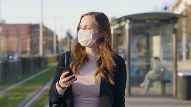 在城市里戴着医用防护口罩的女性通勤者视频素材