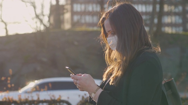 在城市里戴着医用防护口罩的女性通勤者视频素材