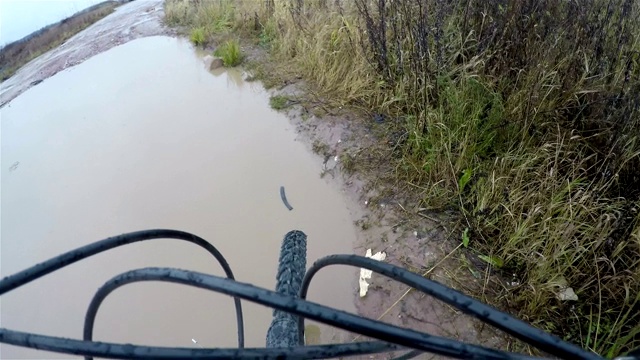 一个男人在一个大水坑里走路，还推着一辆自行车视频下载
