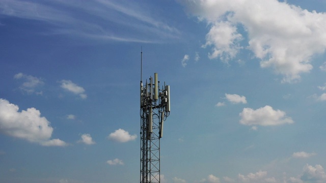 电信塔周围的近景鸟瞰图。在电信塔的顶部安装了天线和发射器，用于传输lte 5g 4g网络和移动gsm运营商的信号。视频素材