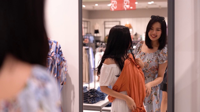 亚洲华人女性在服装零售店购物和浏览视频下载