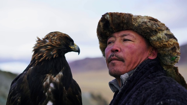 蒙古沙漠中骑着马的猎鹰人的肖像视频下载