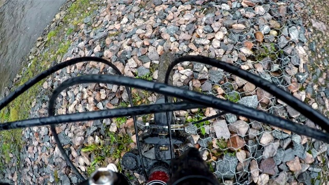 一名运动员在小溪附近的石坡上滚动自行车视频下载