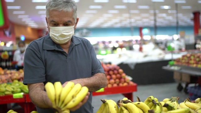 老人戴着一次性医用口罩在超市购物视频素材