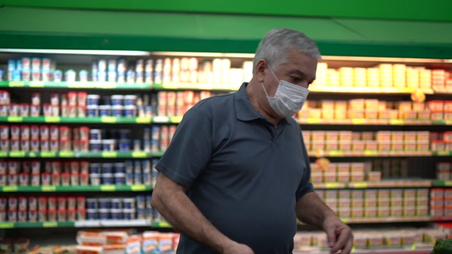老人戴着一次性医用口罩在超市购物视频素材