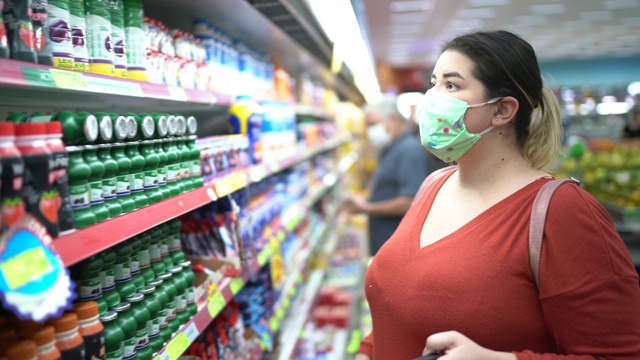 一个女人戴着一次性医用口罩在超市购物视频下载