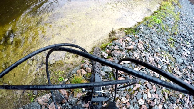 自行车停在石头河岸上，上面盖着一张网视频下载