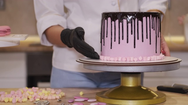 一位女面包师正在用小棉花糖装饰一个生日蛋糕视频下载