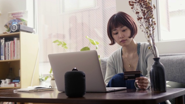 年轻的日本女性成年人用信用卡在网上购物视频素材