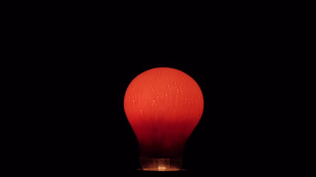 灯泡在黑暗中是红色的。Flash红色。电力。视频下载