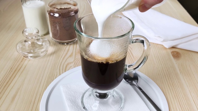 卡布奇诺或拿铁咖啡。将泡沫牛奶倒入一杯咖啡中视频素材