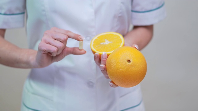 营养学家医生健康生活方式概念-持维他命丸和橙果视频下载