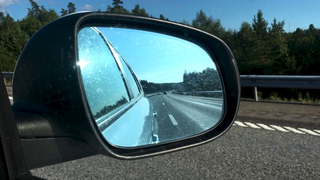 在经过瑞典的高速公路上开车，看看后视镜。视频素材