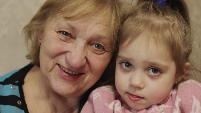 满脸皱纹的祖母拥抱着她的孙女。视频素材