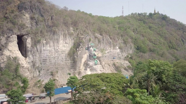 从空中拍摄的绿树显示巨大的佛像和竹脚手架在施工视频素材