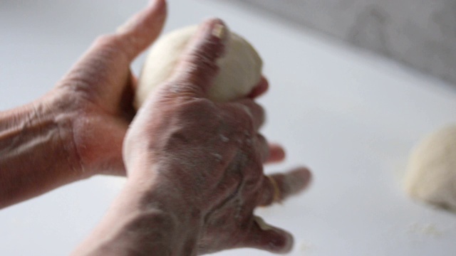 一位年长妇女的手正在准备面团，准备做自制面包或糕点视频素材