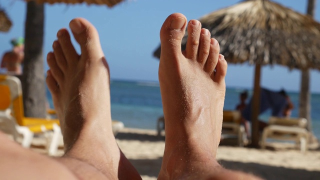 男人的脚在沙滩上放松，宝贝视频下载