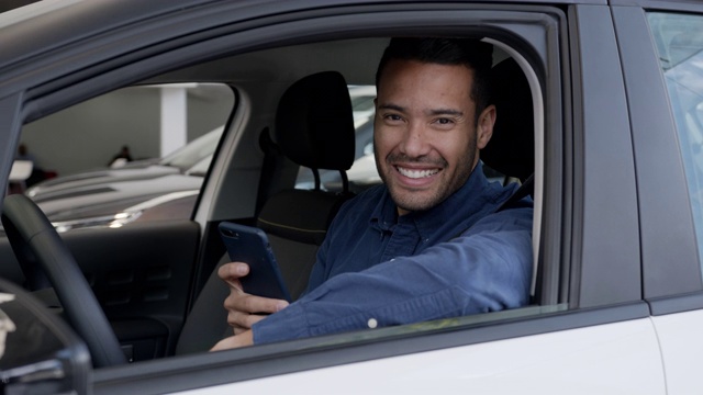 快乐的司机用手机上的GPS应用看着摄像头微笑着视频素材