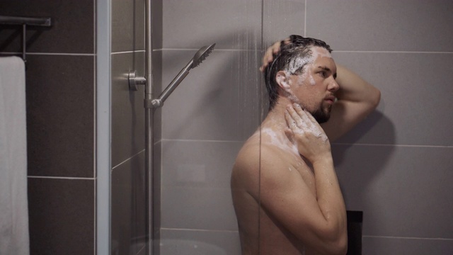 一个成年人正在淋浴中洗头视频素材